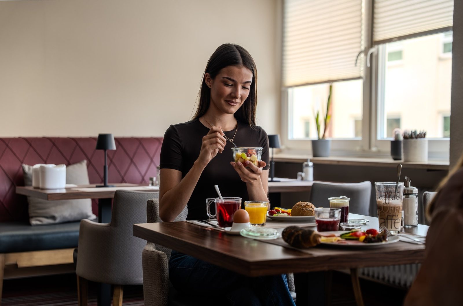 Gast beim Frühstück am Fenster des Hotel Süderelbe