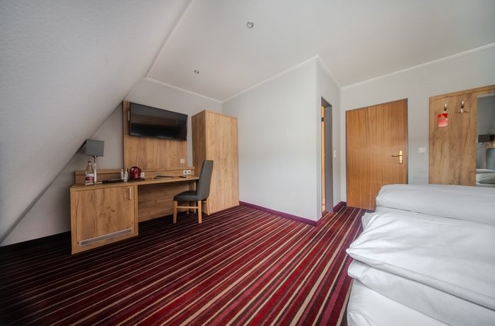 Zimmer mit Schreibtisch und Bett