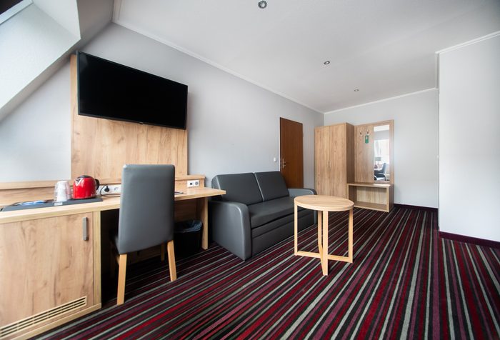 Zimmer mit Sitzecke und Arbeitsplatz